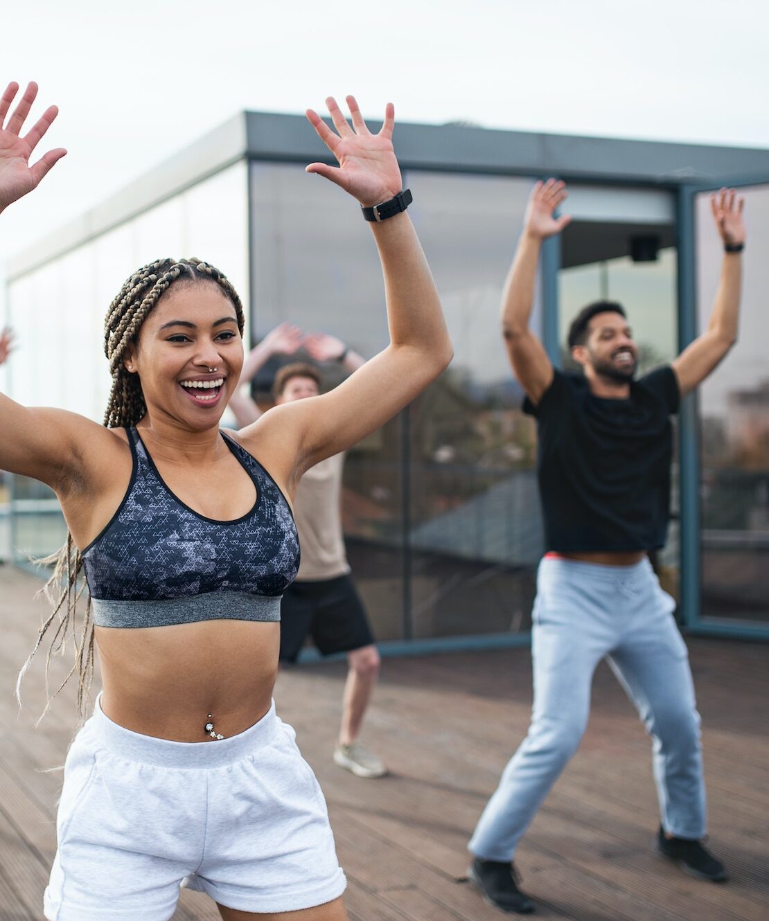 Group of young people doing exercise outdoors on terrace, sport and healthy lifestyle concept