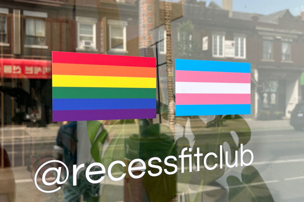 Pride flag and transgender flag on Recess Fit Club window glass